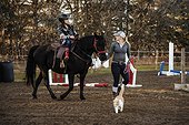 A trainer working with a young girl with Cerebral Palsy during a Hippotherapy session; Westlock, Alberta, Canada