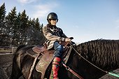 A young girl with Cerebral Palsy riding a horse during a Hippotherapy session; Westlock, Alberta, Canada