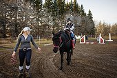 A young girl with Cerebral Palsy and her trainer working with a horse during a Hippotherapy session; Westlock, Alberta, Canada