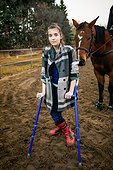 A young girl with Cerebral Palsy walking in a corral during a Hippotherapy session; Westlock, Alberta, Canada