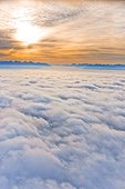 Aerial photo of the sun rising above the Chugach Mountains with fog covering Cook Inlet, Southcentral Alaska, Autumn