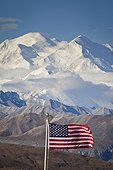 An American flag flys in the wind at Eielson Visitor Center with Mt. Mckinley looming in the background, Denali National Park and Preserve, Interior Alaska, Autumn