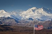 An American flag flys in the wind at Eielson Visitor Center with Mt. Mckinley looming in the background, Denali National Park and Preserve, Interior Alaska, Autumn