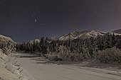 The Big Dipper constellation and shooting stars over the Chugach Mountains (Polar Bear Peak, Eagle Peak, and Hurdygurdy Mountain) along the frozen Eagle River in Chugach State Park in Southcentral Alaska, Winter