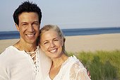 Portrait of a mature couple standing on the beach and smiling
