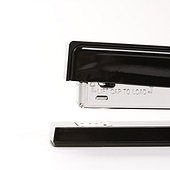 Close up of black stapler on white background.