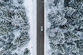Aerial View Of Winter Road With A Car And Snow Covered Forest In Finland
