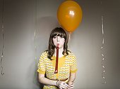 Studio shot of woman with balloon and party blower