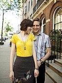 USA, New York, New York City, Portrait of young couple in front of apartment building