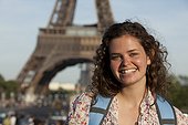 France, Paris, Portrait of young woman in front of Eiffel Tower
