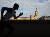 UK, London, Man running in front of Westminster skyline