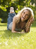 UK, London, Young woman lying in park and laughing