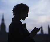 Silhouette of mid adult woman using phone