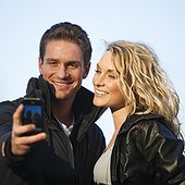 UK, London, Young couple taking picture using smartphone