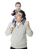 Father carrying son (2-3) on shoulders, studio shot