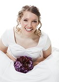 Portrait of happy bride holding bouquet, studio shot