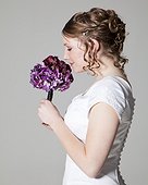 Portrait of happy bride holding bouquet, studio shot