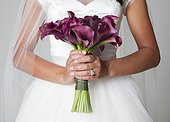 Mid section of bride holding bouquet