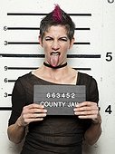 Studio mugshot of mature woman sticking out tongue