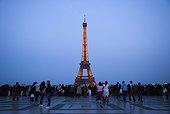 France, Paris, Tourists looking at Eiffel Tower illuminated at dusk