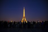 France, Paris, Tourists looking at Eiffel Tower illuminated at night