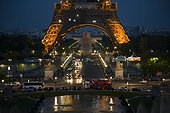 France, Paris, Traffic on avenue and Eiffel Tower illuminated at night