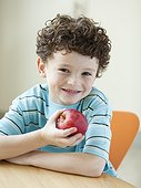 USA, Utah, Portrait of smiling boy (6-7) holding red apple