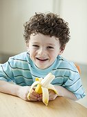 USA, Utah, Portrait of smiling boy (6-7) holding banana