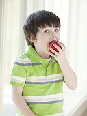 USA, Utah, Portrait of smiling boy (4-5) biting apple