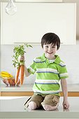 USA, Utah, Portrait of smiling boy (4-5) holding bunch of carrot