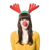 Studio shot of young woman wearing antlers and red nose