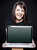 Studio portrait of woman holding laptop