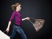 Portrait of a young woman holding shopping bags,studio shot