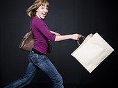 Young woman running with shopping bag