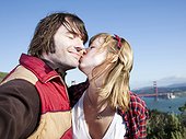 USA,California,San Francisco,Young couple kissing with Golden Gate Bridge in background