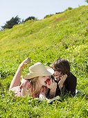USA,California,San Francisco,Young couple lying on grass eating apple