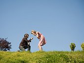 USA,California,San Francisco,Young man proposing in park to surprised girlfriend