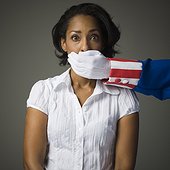Studio shot of Uncle Sam covering mouth of young woman