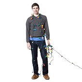 Studio shot of young man wrapped in christmas lights