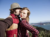 USA,California,San Francisco,Young couple embracing,with Golden Gate Bridge in background