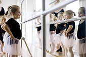 Mature woman teaching girls (12-13,14-15,16-17) ballet in studio