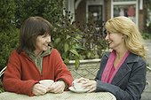 Two mature women having tea and smiling