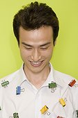 Close-up of a young man with paper clips on his shirt and smiling