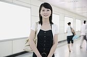 Portrait of a young woman standing in a corridor and smiling