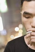 Close-up of a young man smoking a cigarette