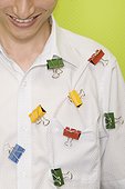 Close-up of a young man smiling with paper clips on his shirt