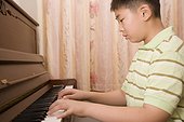 Close-up of a boy playing a piano