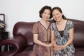 Portrait of two mature women sitting on a couch and smiling
