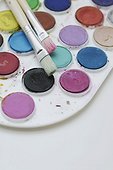 Close-up of a color palette with paintbrushes