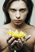 Portrait of a young man holding a sunflower